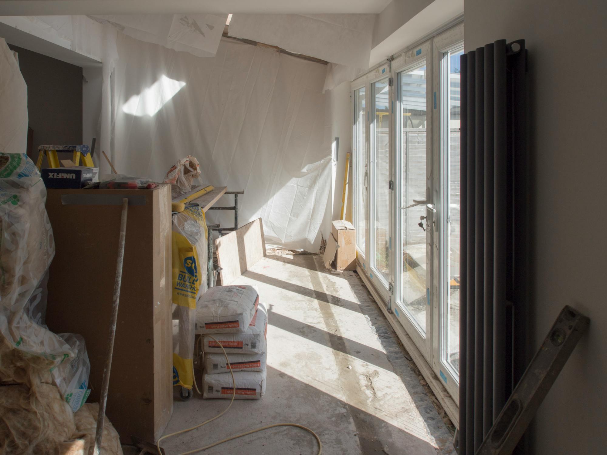 A residential interior mid-construction — raw concrete and natural light